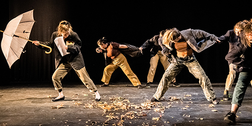 four students on stage performing